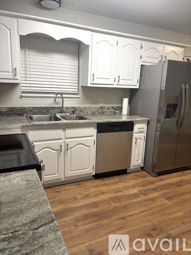 A kitchen with white cabinets and a granite countertop.