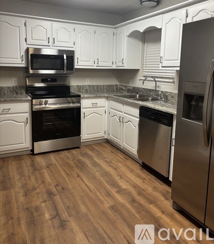 A kitchen with white cabinets and stainless steel appliances.