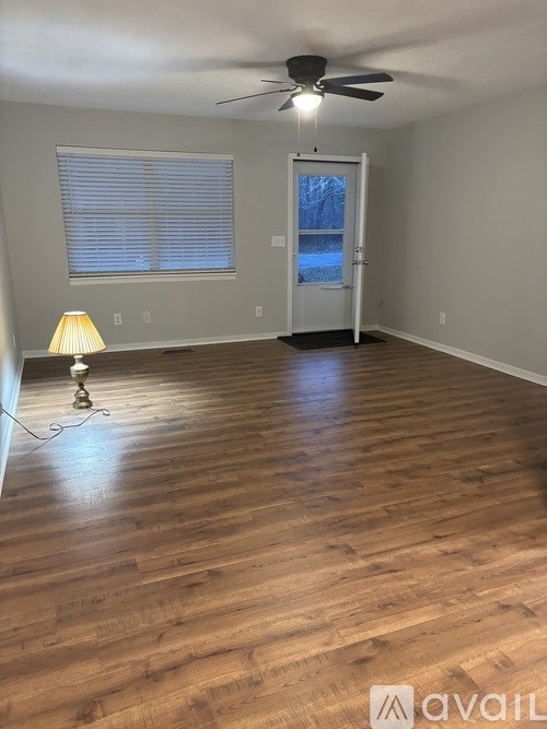 A room with wooden flooring and a ceiling fan.