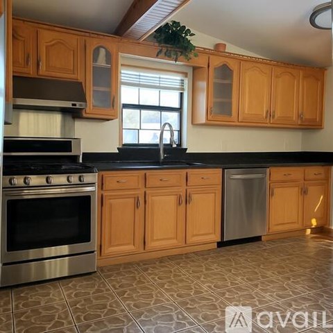 A kitchen with wooden cabinets and a black countertop.