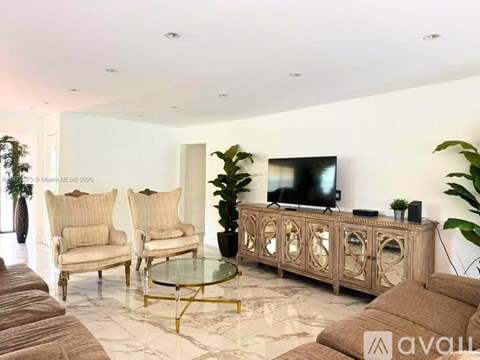 A living room with a glass coffee table and a TV on a wooden cabinet.