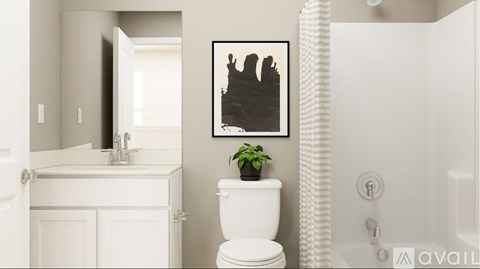 A bathroom with a toilet, sink, and a picture on the wall.