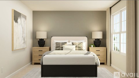 A bedroom with a large bed, two lamps, and two nightstands.