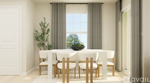 A dining room with a white table and chairs.