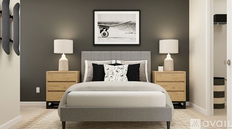 A bedroom with a large bed, two nightstands, and a framed picture on the wall.