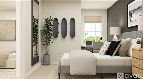 A modern bedroom with a large bed, a white chair, and a potted plant.