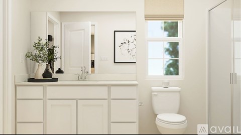 A white bathroom with a toilet, sink, and a mirror.