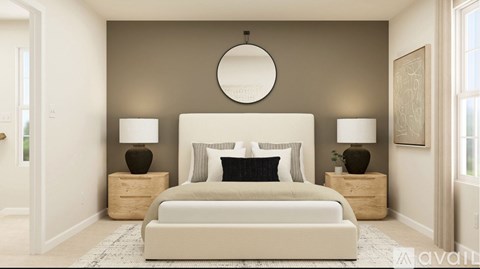 A bedroom with a large bed, two lamps, and a round mirror on the wall.