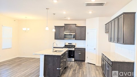A kitchen with dark wood cabinets and a white countertop.