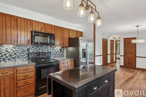 A kitchen with wooden cabinets and a black stove top oven.