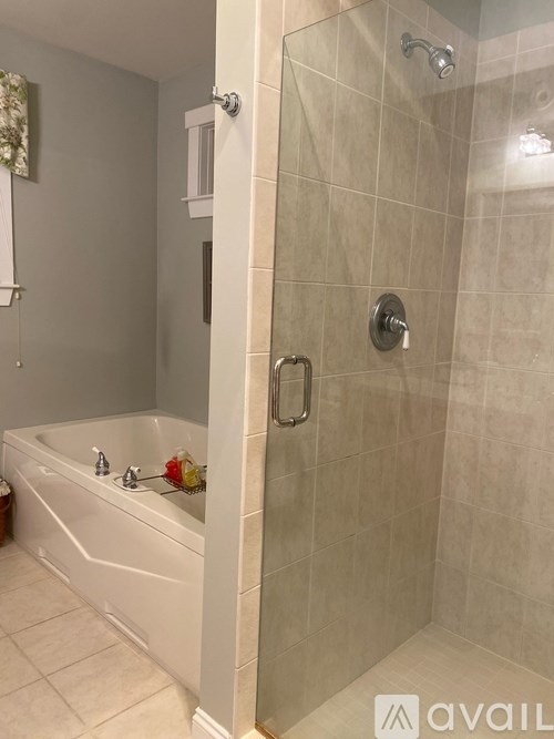 A white bathtub with a shower door in a bathroom.