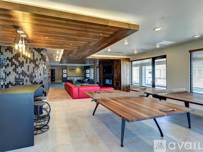 A modern living room with a wooden ceiling and a large wooden table.