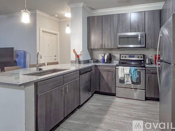 A modern kitchen with stainless steel appliances and wooden cabinets.
