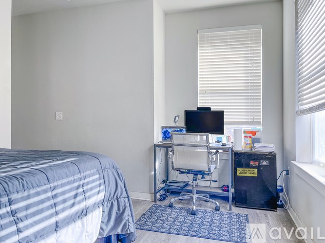 A bedroom with a bed, desk, and chair.