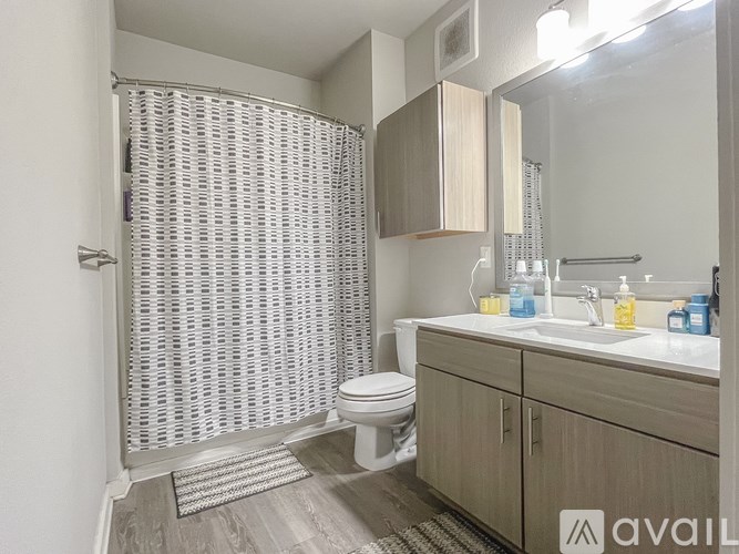 A bathroom with a toilet, sink, and shower.