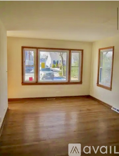A room with wooden floors and two windows.