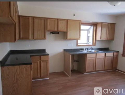 A kitchen with wooden cabinets and a black countertop.