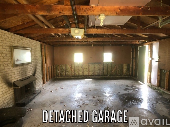 A detached garage with a brick wall and a window.