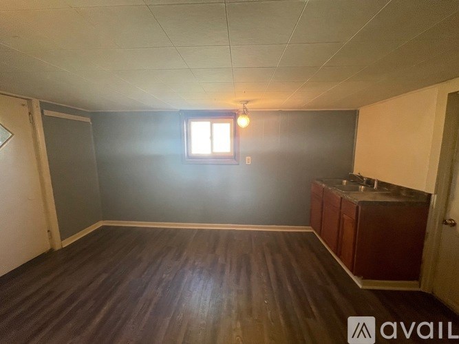 A room with wooden flooring and a window.
