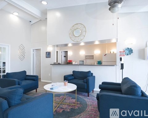 A living room with blue chairs and a white table.