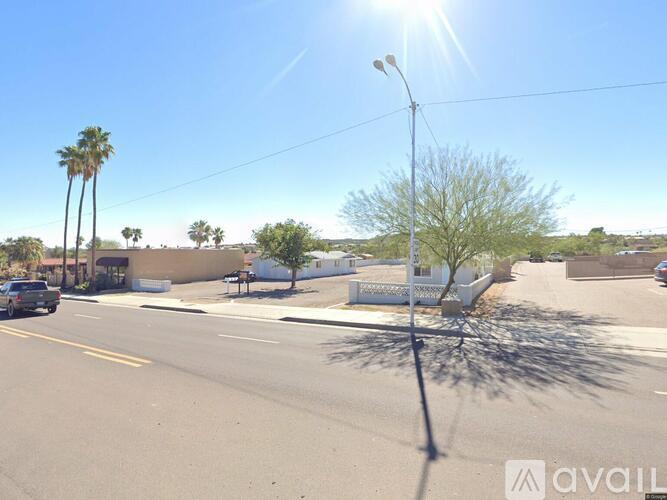 A street view with a clear blue sky and a palm tree.