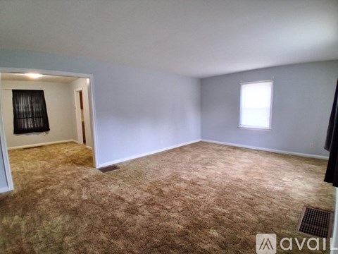 A room with a carpeted floor and a window.