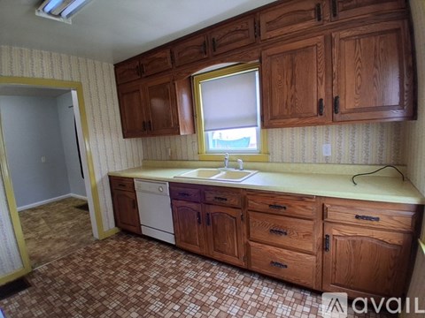 A kitchen with wooden cabinets and a tiled floor.