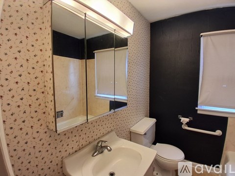 A bathroom with a floral wallpaper and a white sink.