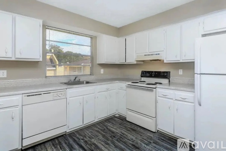 A kitchen with white cabinets and appliances.