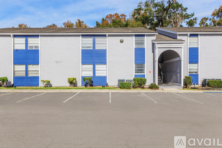 A building with a white facade and blue doors is available for rent.