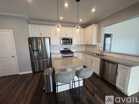 A kitchen with a refrigerator, microwave, and a counter with a sink.