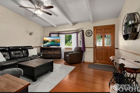 A living room with a black leather couch and a wooden coffee table.
