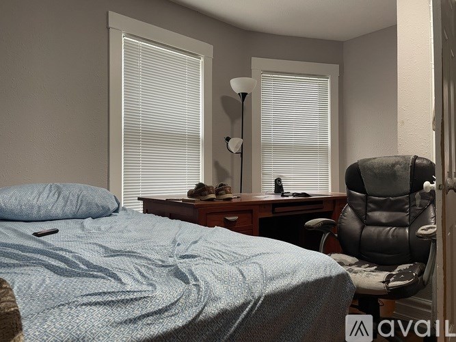 A bedroom with a bed, desk, and chair.