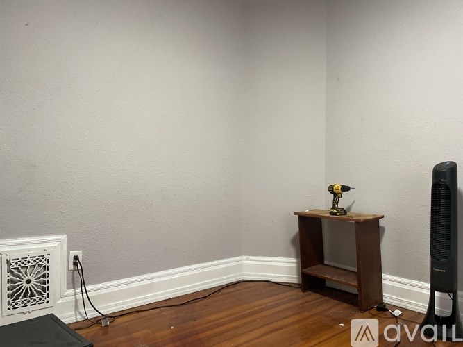 A room with a wooden shelf and a black speaker.