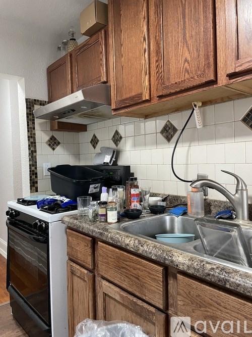 A kitchen with wooden cabinets and a white stove top oven.