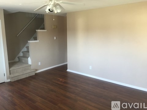 A room with a staircase and a ceiling fan.