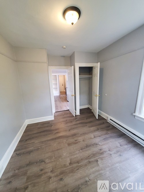 A room with wooden flooring and white walls.