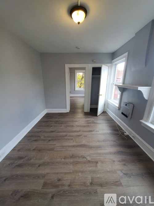 A hallway with wooden floors and white walls.