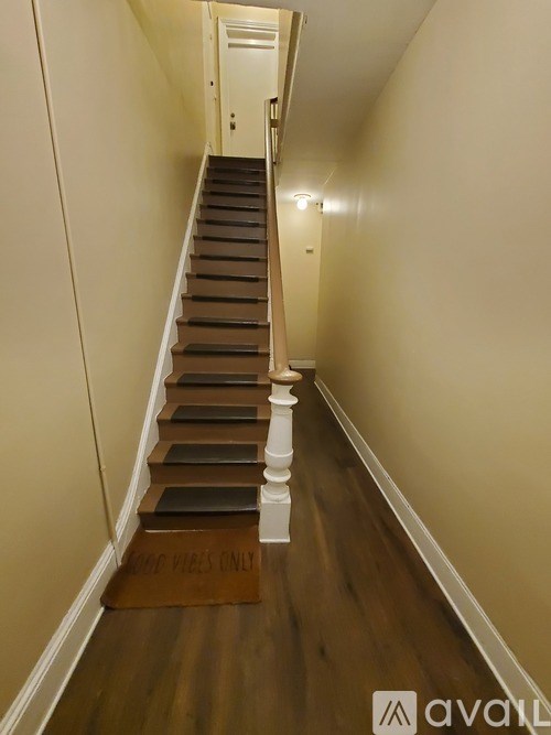 A staircase with a sign that says "NO SMOKING ON STAIRS ONLY" on the bottom step.