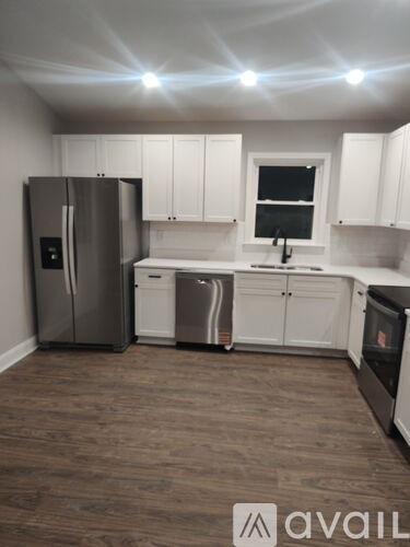 A kitchen with white cabinets and a stainless steel refrigerator.