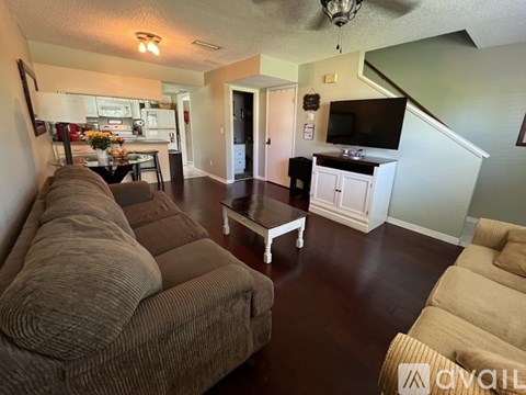 A living room with a brown couch and a white coffee table.