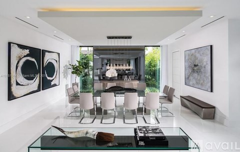A modern dining room with a glass table and chairs.