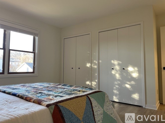 A bedroom with a bed and two wardrobes.
