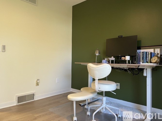A room with a green wall and a white chair.