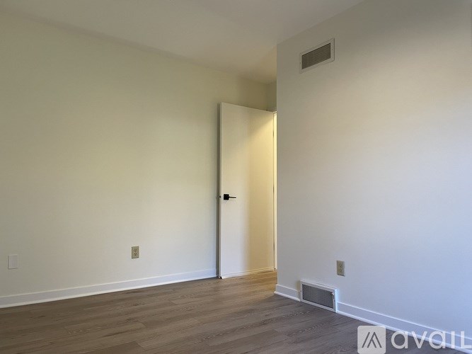 A room with a door and a wooden floor.