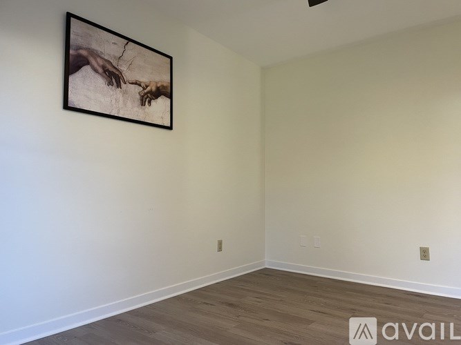 A room with a framed picture of two hands on the wall.