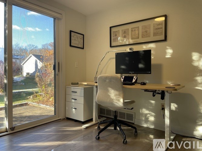 A room with a desk, chair, and a monitor.