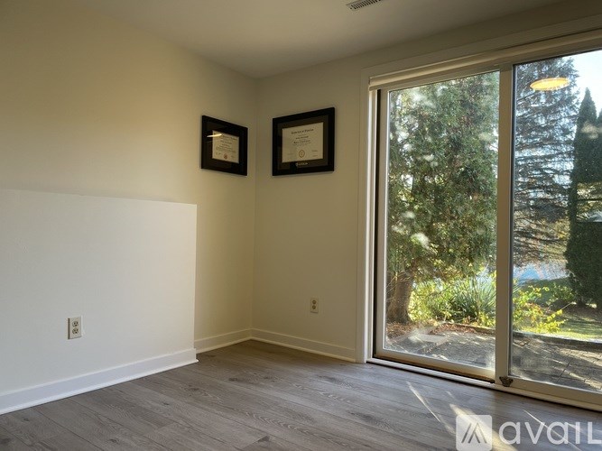A room with a sliding glass door leading to a garden.