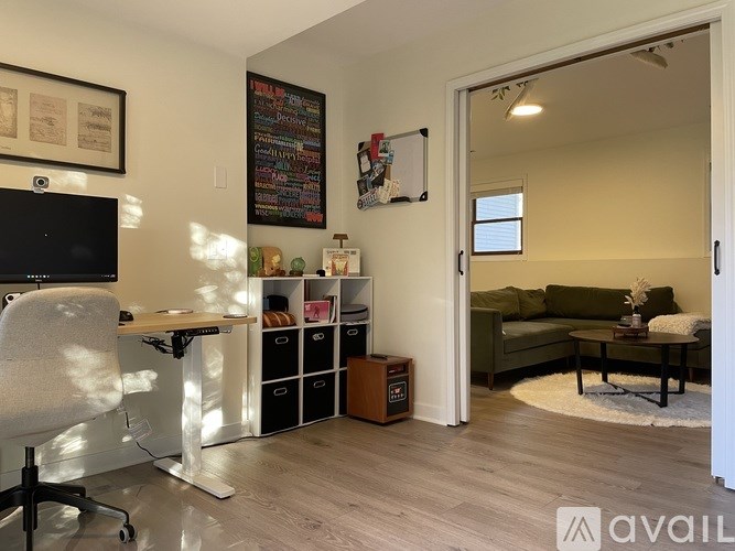 A room with a desk, chair, and a couch.