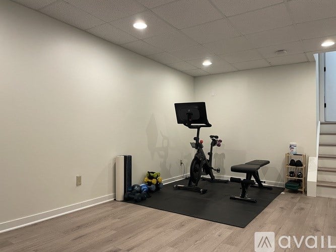 A room with exercise equipment and a black mat.